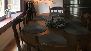 A dining area with a wooden table, chairs, and a Christmas tree decoration. - Modern house, Hot Tube, lakes, pools, water parks, Ski, tennis A/C Free WiFi (Albrightsville)