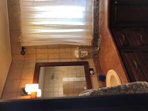 A bathroom with a tiled floor, a shower area, a toilet, and a sink. - Spectacular Lake Arenal and Mountain view rental (Tilaran)
