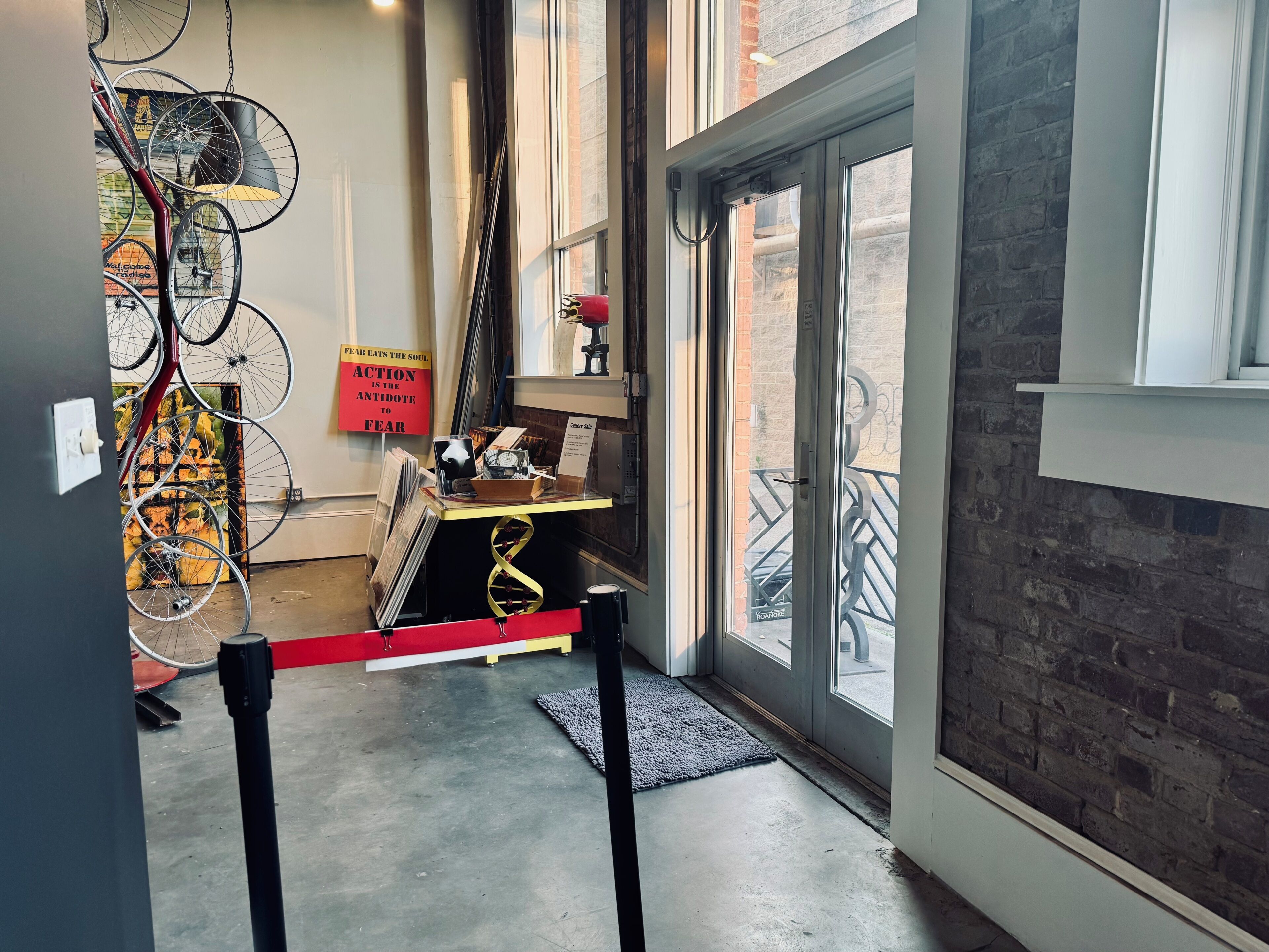 Une pièce dotée d’une grande fenêtre, d’une porte et d’un support à vélos fixé au mur.