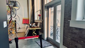 A room with a large window, a door, and a wall-mounted bicycle rack. - Artist's Loft/Walk Downtown Roanoke/Free Onsite Parking/Historic Building (Roanoke)
