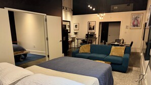 Una habitación de hotel moderna con una cama grande, un sofá y una zona de escritorio.