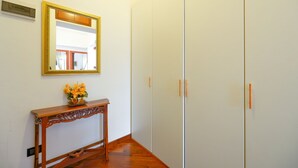 A hallway with a wooden console table, a mirror, and a wardrobe.