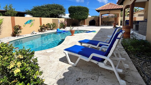A swimming pool with lounge chairs, a mural of a sea turtle, and a covered patio area. - Piece of Paradise... Eagle Beach Villa with Private Pool;  Great Location! (Aruba)
