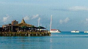 A waterfront restaurant with outdoor seating, boats, and a pier extending into the water. - Piece of Paradise... Eagle Beach Villa with Private Pool;  Great Location! (Aruba)