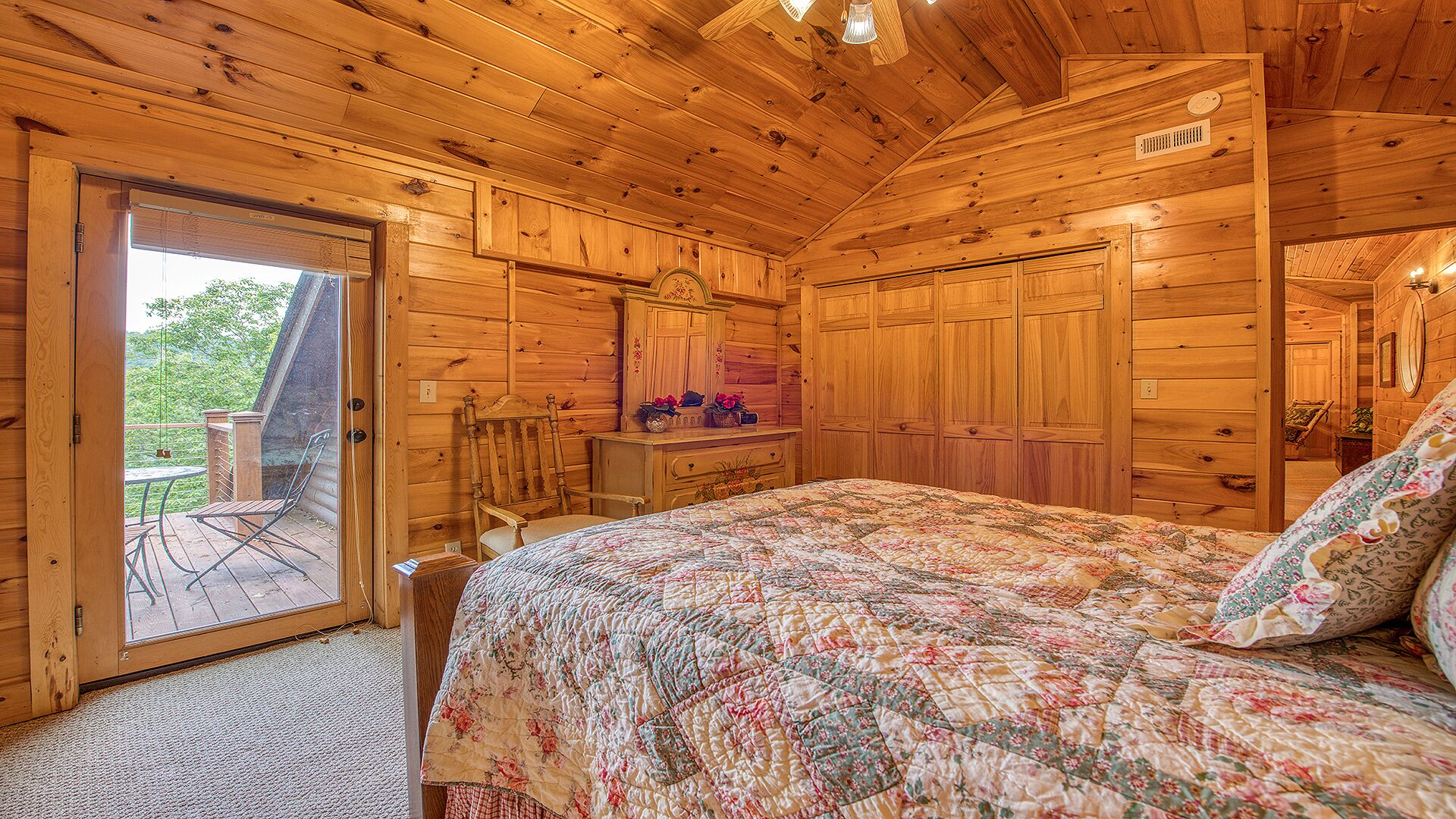 Ein Schlafzimmer in einer Holzhütte mit einem Bett, einem Schminktisch und einem Stuhl.