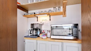 Una cocina equipada con cafetera, microondas y armarios.