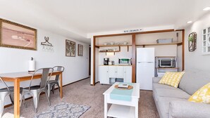 Un espacio habitable compacto con comedor, kitchenette y sofá.