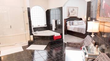 Une salle de bain luxueuse dotée d’une grande baignoire, d’une douche séparée et d’un coin salon confortable agrémenté d’un miroir et d’objets décoratifs.