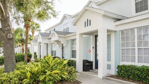 Fila de casas adosadas modernas de dos pisos, con un estilo arquitectónico uniforme, grandes ventanales y fachada blanca y despejada.