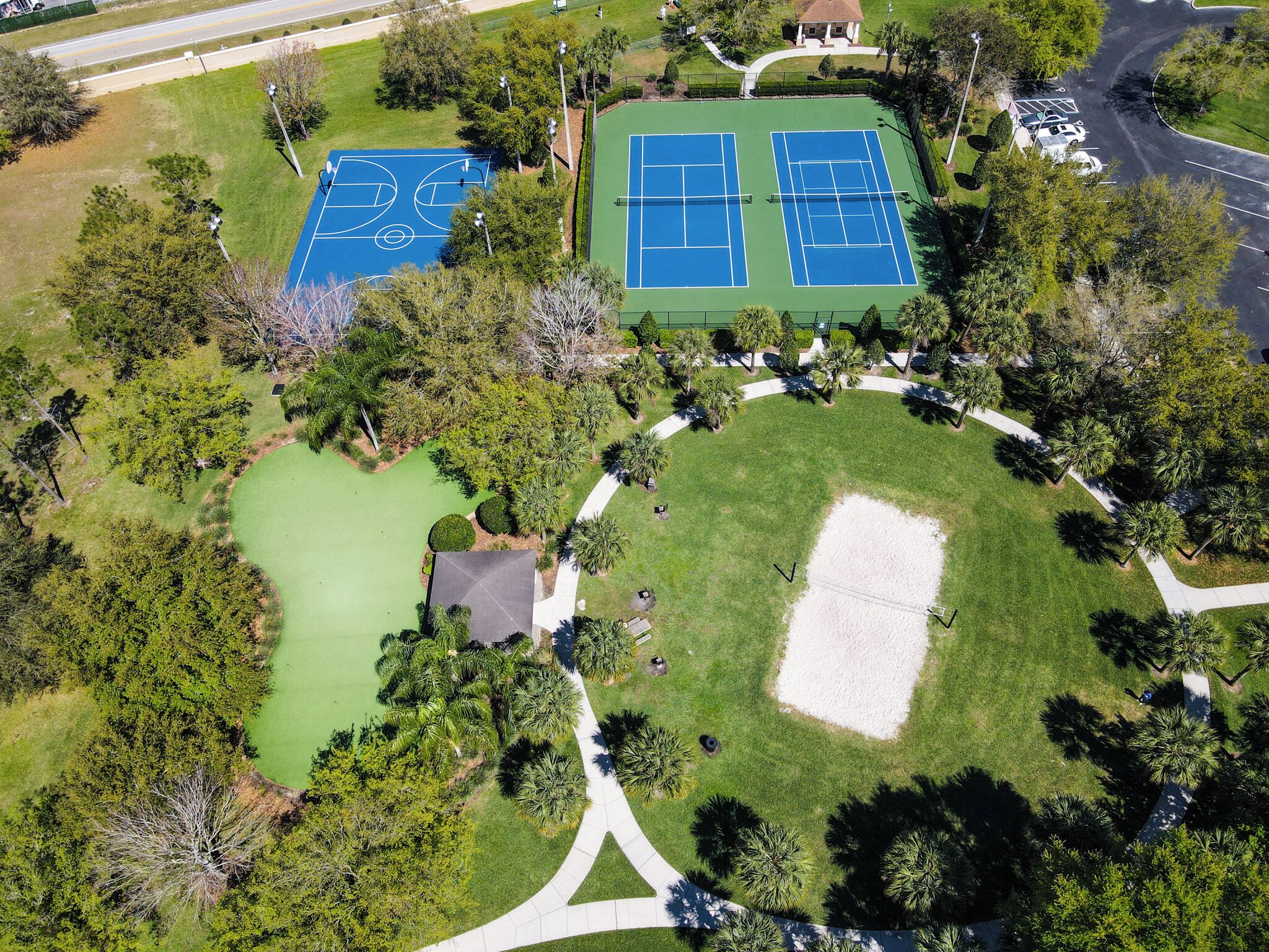 Luchtbeeld van een park met tennisbanen, een golfbaan en wandelpaden.