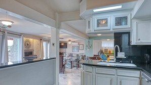 Una cocina amplia con armarios blancos, una isla grande y un comedor con mesa y sillas.