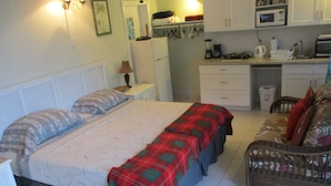 A compact bedroom with a bed, bedside tables, a small desk, and a chair. - HOOPERS BAY PRIME BEACHFRONT  KING or TWIN  STUDIO  and with STARLINK fast WIFI (Georgetown)