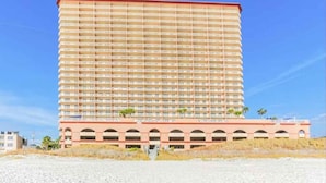 Un hotel moderno de gran altura, con varios pisos, techo plano y una serie de balcones.