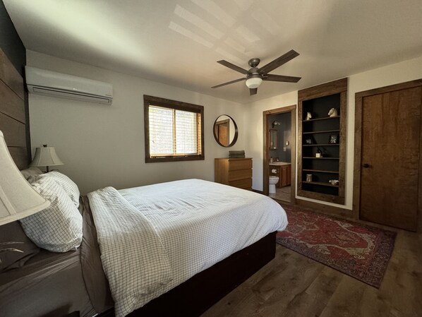 A bedroom with a bed, dresser, vanity, and a walk-in closet. - Huge 3000sqf Creek Front - 8 person hot tub, Fire pit, two decks, Ski Hill. (Bushkill)