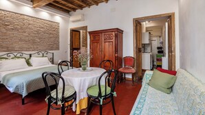 Une pièce comprenant deux lits, une table à manger avec des chaises, un meuble en bois et un canapé.