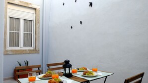 A table set for breakfast with plates of food, glasses of juice, and a lantern. - Travessa House I - Graça. Lisbon Historic Center (Lisbon)