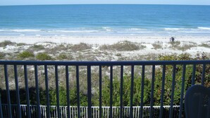 A beach view from a balcony with a railing, sandy beach, and ocean. - Special Nov 28 - Dec 19, 2026 - IRB Direct Beach Front Corner Condo (Indian Rocks Beach)