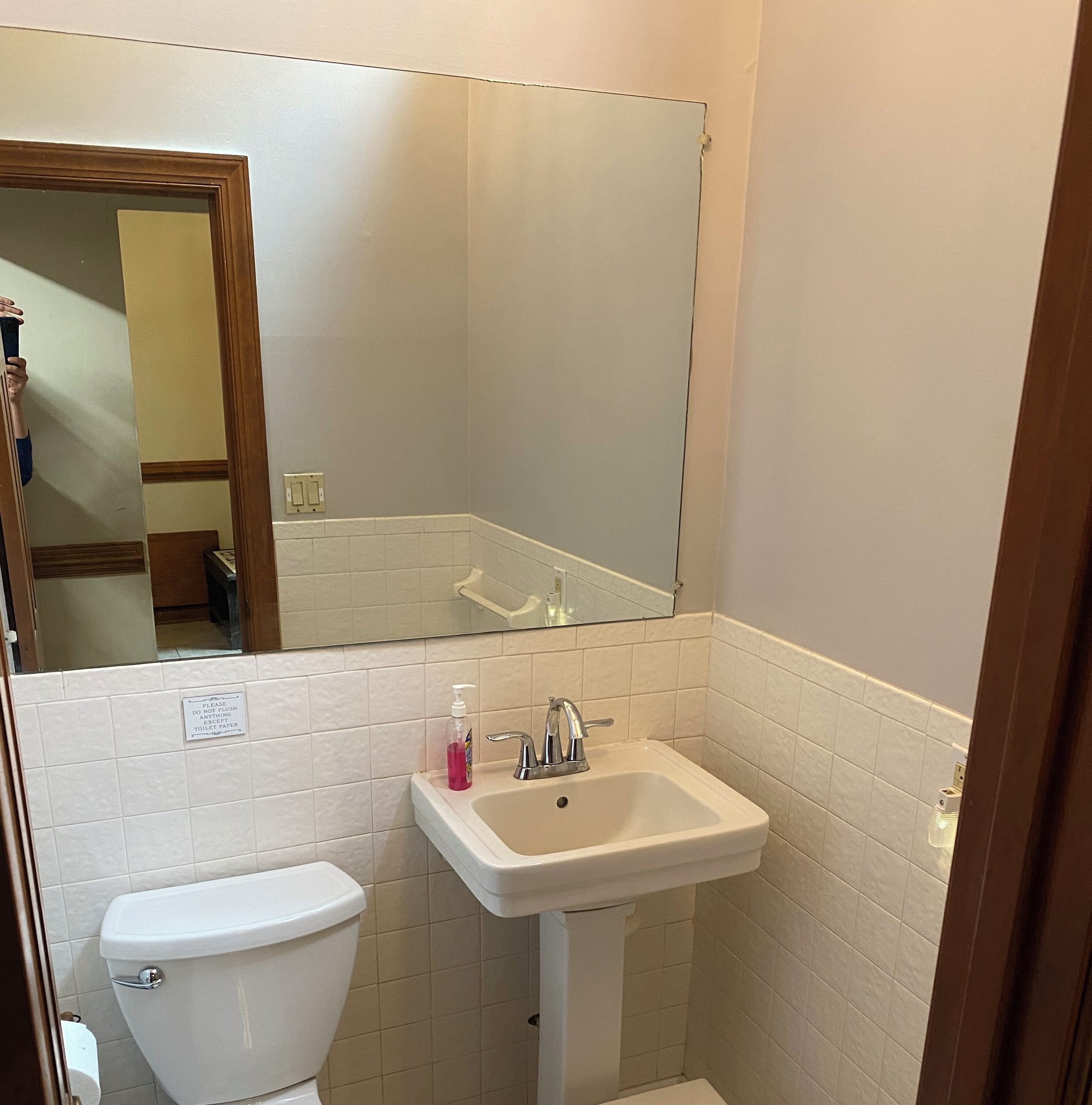 Une petite salle de bain avec des toilettes, un lavabo et un miroir.