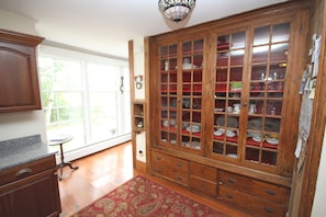 A traditional kitchen with wooden cabinets, a built-in china cabinet, and a patterned rug. - "Old River House", FAMOUS HISTORIC ELEGANCE. Waterfront/Crashing Ocean Sounds  (Kennebunkport)