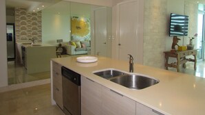 A modern kitchen with a dishwasher, double sink, and a large island.