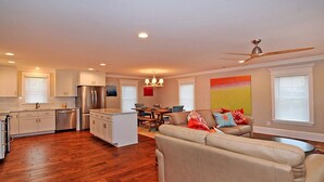 A spacious living area with a sofa, dining table, and kitchen.