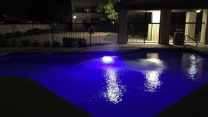 Una piscina iluminada con luces azules durante la noche.