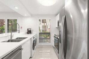 Une cuisine moderne équipée d’appareils électroménagers en acier inoxydable, d’un lave-vaisselle et d’un four encastré.