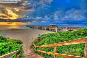 A wooden pier extending into the ocean with a gazebo at the end.