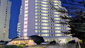 Ein mehrstöckiges Hotel mit modernem Design, gekennzeichnet durch einen markanten, vertikalen Abschnitt und zahlreiche Balkone.