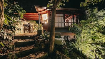 A traditional Japanese-style building with a stone pathway leading to the entrance, surrounded by lush greenery.