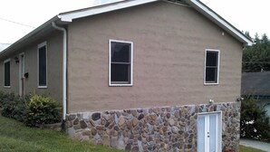 A two-story house with a stone foundation and a beige exterior. - Apartment in town (Franklin)