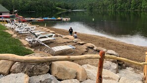 Una zona a la vora d'un llac amb gandules i un moll amb barques.