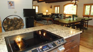 A kitchen with a stove, dining table, and seating area.