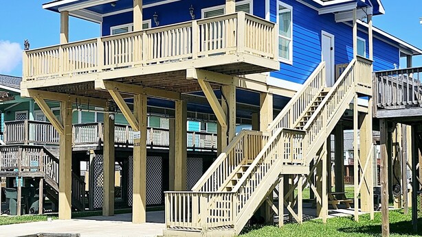 Un bâtiment à deux étages doté d’un balcon et d’un escalier en bois.