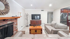 A living room with a fireplace, a television, a sofa, and a coffee table.