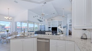 Una cocina moderna con armarios blancos, lavavajillas integrado y encimera de granito.