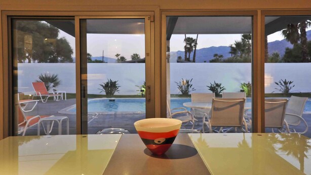 A hotel room with a view of a pool and palm trees. - Contemporary Home with WiFi,Salt Water Pool, Jacuzzi-Your Own Retreat! (palm springs)