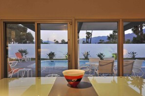 A hotel room with a view of a pool and palm trees. - Contemporary Home with WiFi,Salt Water Pool, Jacuzzi-Your Own Retreat! (palm springs)