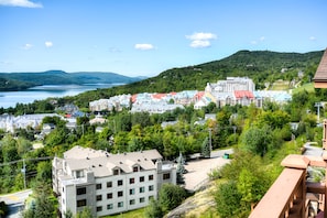 A town with a lake, surrounded by hills and greenery.