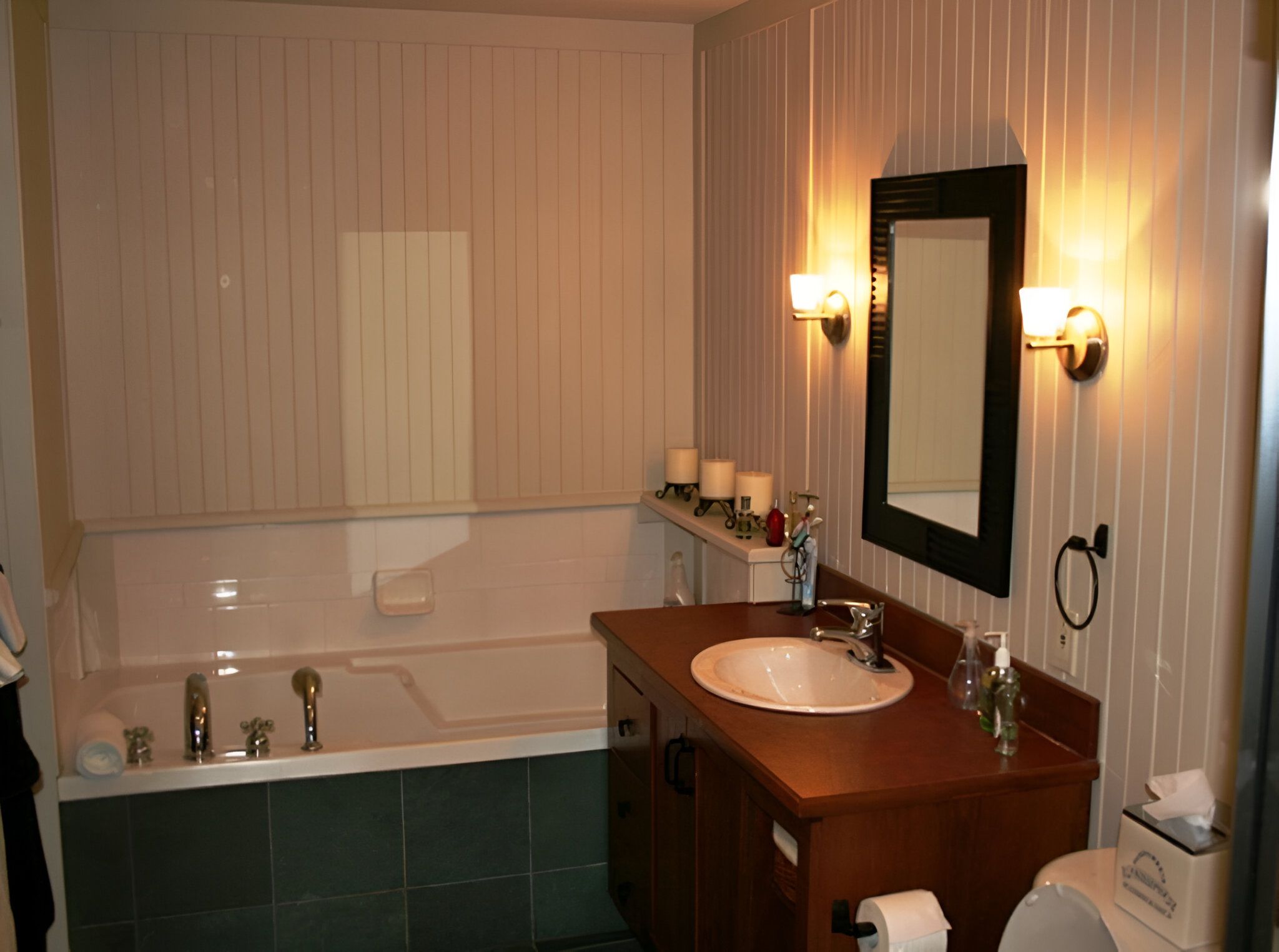 Une salle de bain avec une baignoire, un lavabo, un miroir et un porte-serviettes.