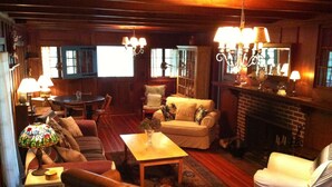 Una sala de estar acogedora con chimenea, muebles de madera y una lámpara de vitral.