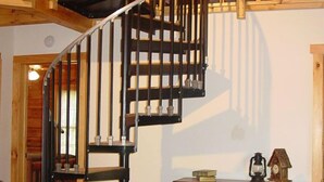 Eine Holztreppe mit Metallgeländer, die zu einer oberen Ebene führt.