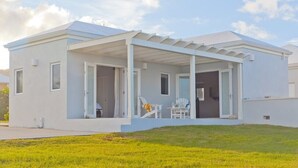 Une maison moderne de plain-pied, dotée d’un porche abrité, de grandes fenêtres et d’une pelouse bien entretenue.