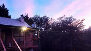 A rustic cabin with a staircase leading to a deck, surrounded by trees and a dirt path. - Private Hideaway near Pigeon Forge; Convenient to Attractions; Five-Star Reviews (Sevierville)