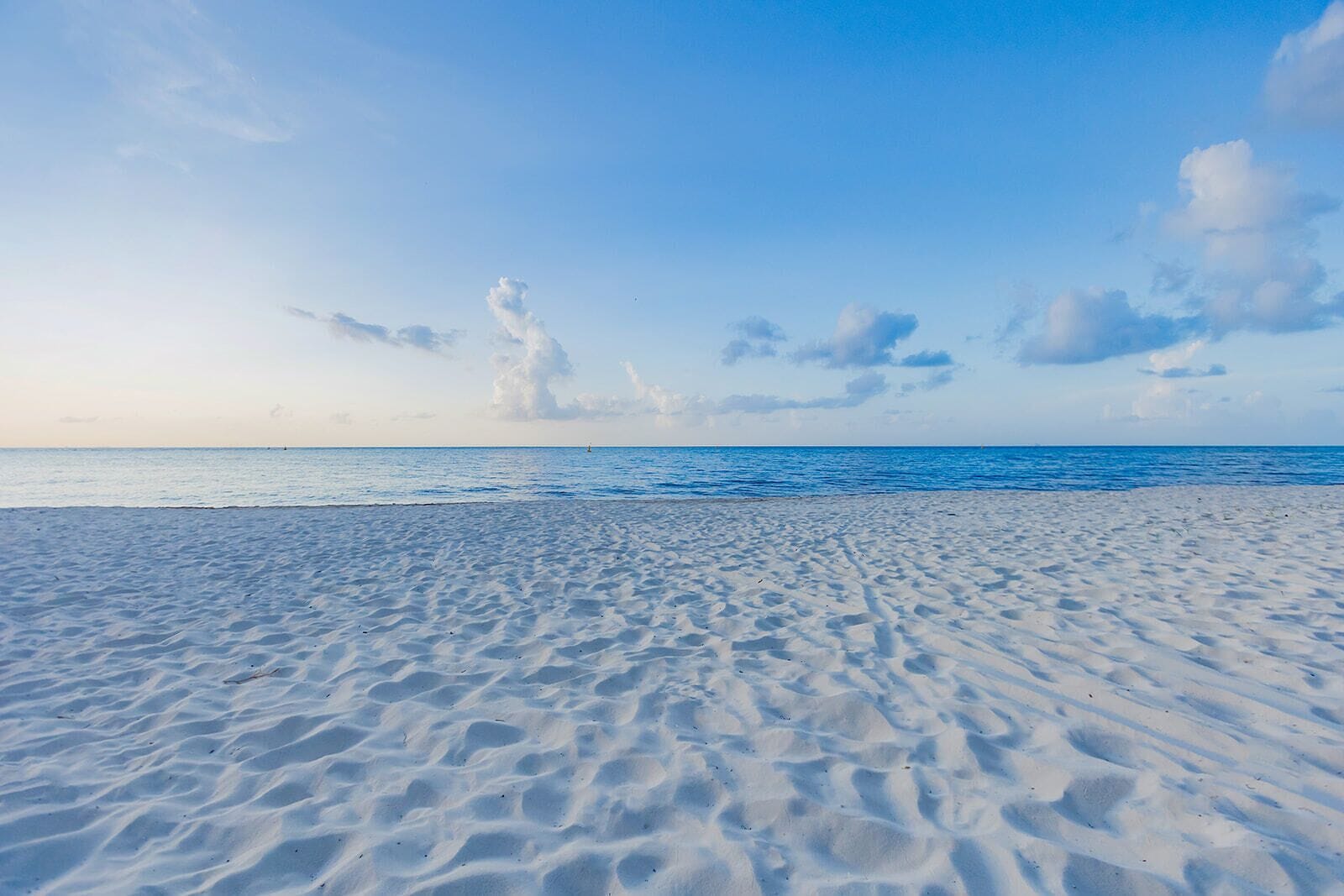 A beach with a clear sky and calm sea.