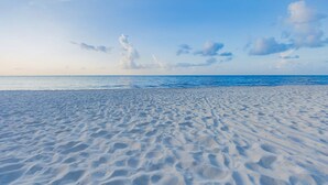 Une plage avec un ciel dégagé et une mer calme.