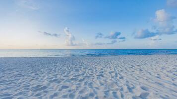 A beach with a clear sky and calm sea.
