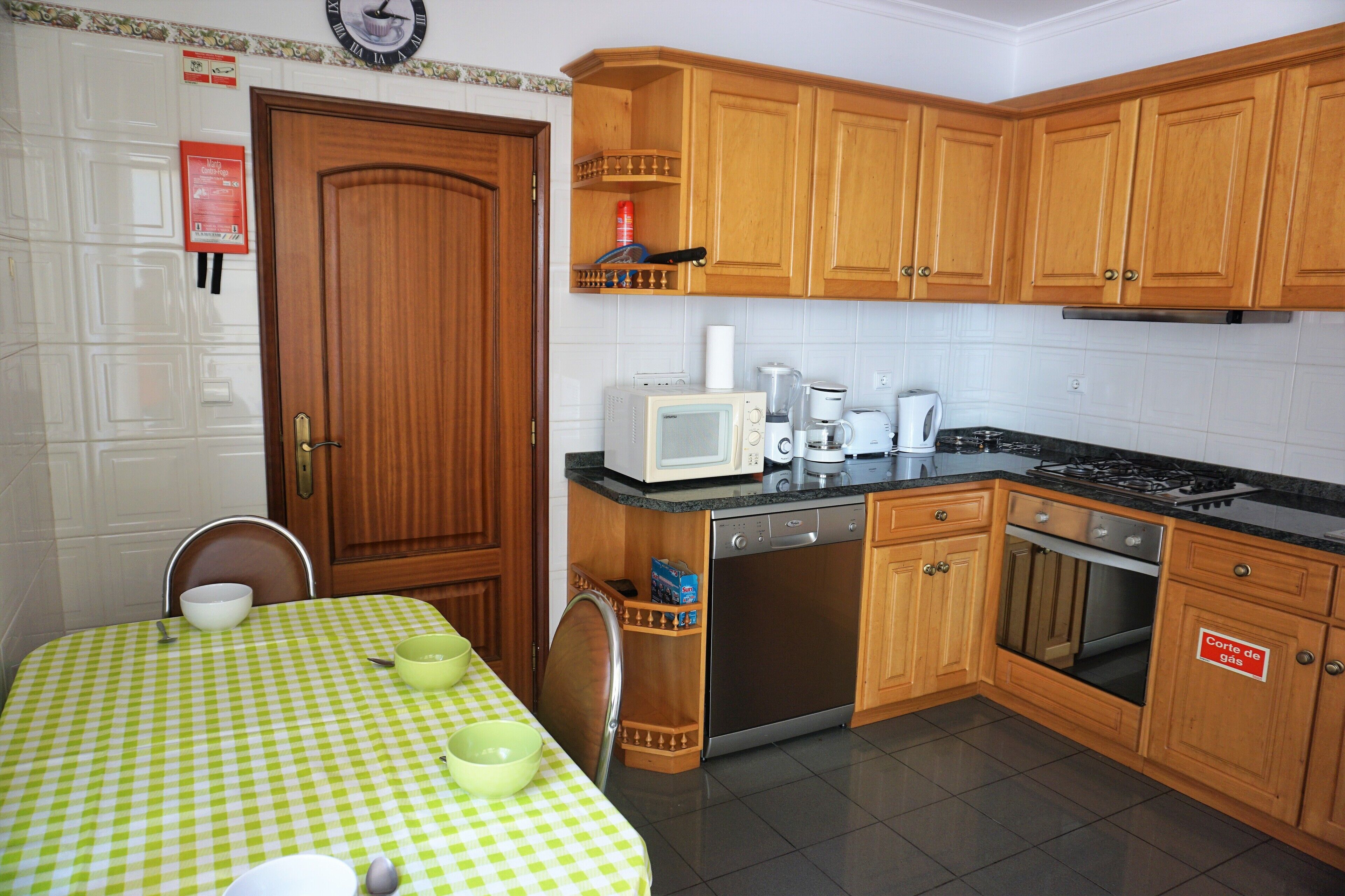 A kitchen with wooden cabinets, a microwave, a stove, and a dishwasher.