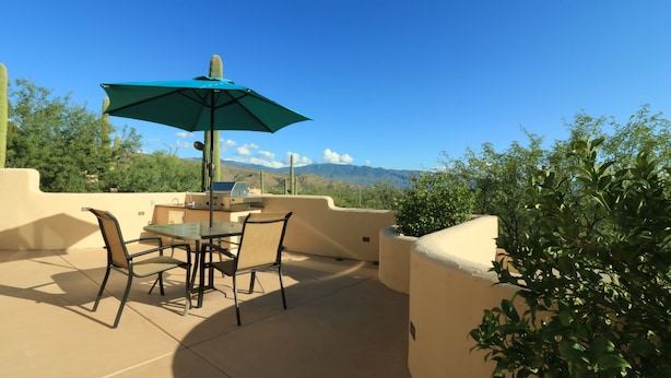 An outdoor patio with a table and chairs, a grill, and a view of mountains. - Amazing City And Mountain Views From The Foothills Of The Catalinas (Tucson)