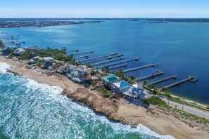 Une propriété située sur la côte, comprenant plusieurs bâtiments, une jetée et une plage.